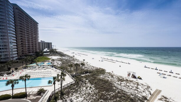 A beach resort with a pool, beach chairs, and a view of the ocean. - D504 Gulf Front Views, 3 pools, Tennis (Panama City Beach)