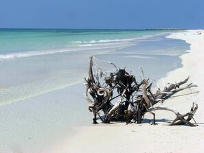 A beach with clear turquoise water and white sand.
