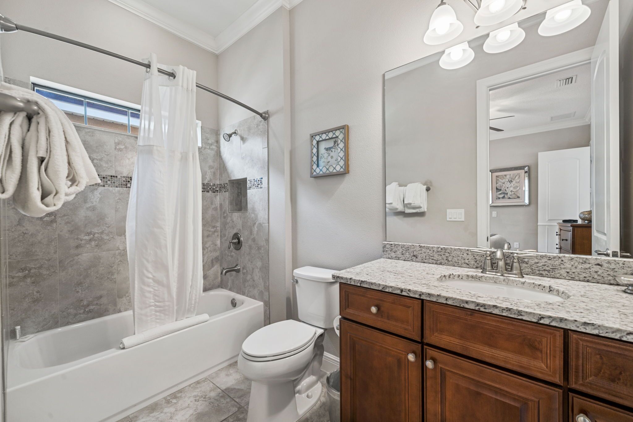 A modern bathroom with a shower, bathtub, toilet, and vanity with a sink.