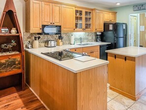A kitchen with wooden cabinets, a microwave, a refrigerator, and a sink. - Townhome D2 - Vacation Rental on 4th Lake (Inlet)