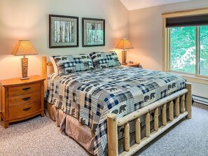 A bedroom with a bed, two bedside tables, a window, and two wall-mounted pictures. - Townhome D2 - Vacation Rental on 4th Lake (Inlet)
