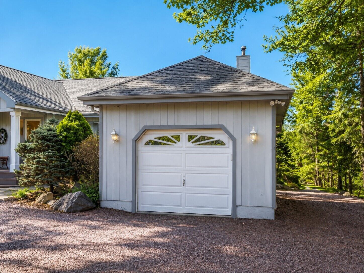 A house with a garage, a chimney, and a well-maintained driveway.