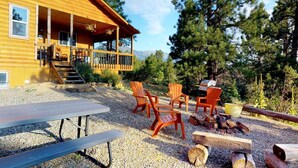 A wooden cabin with a porch, outdoor seating, and a grill. - W-W: Guest Ranch Group Lodging up to 70! (Monticello)