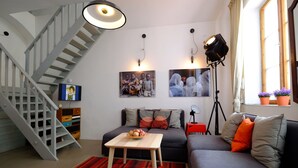 Un salon moderne avec un escalier, un canapé, une table basse et un lampadaire.