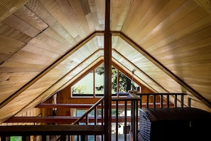 Enjoy a cozy stay in this charming attic room with a large window offering a view of the outdoors.