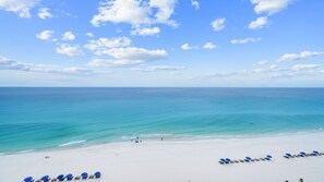 Une plage de sable blanc, une mer d’un bleu limpide et quelques personnes.