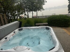 Un jacuzzi con vistas a un lago y una valla de madera.