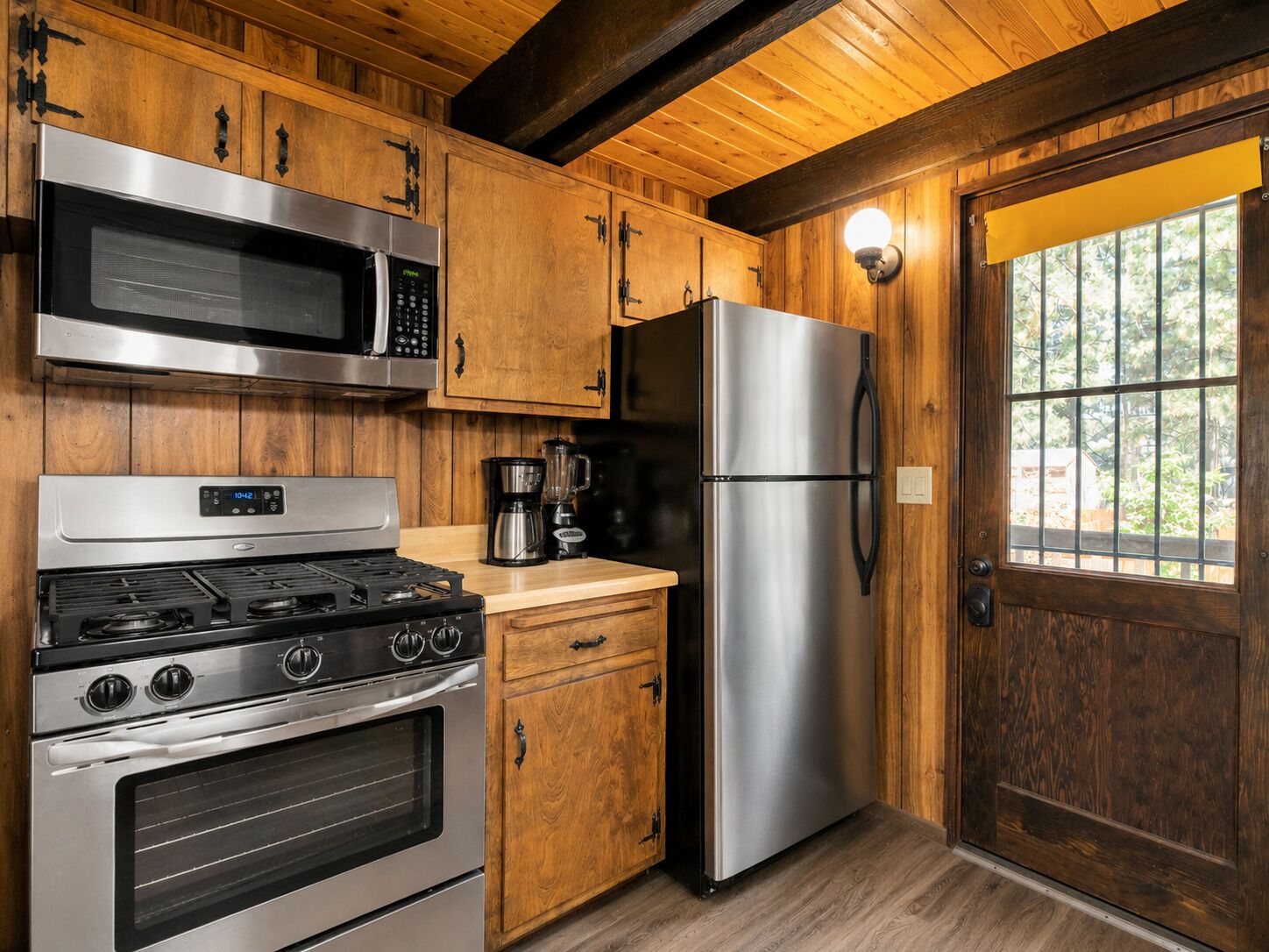 Une cuisine dotée de meubles en bois, d’appareils électroménagers en acier inoxydable, d’une cuisinière, d’un four, d’un four à micro-ondes et d’un réfrigérateur.
