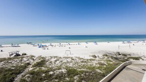 A beach with white sand, clear blue water, and several blue umbrellas. - D303 Low Floor, Direct Gulf View, 3 pools (Panama City Beach)