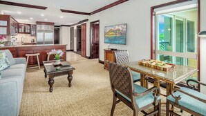 A spacious living area with a kitchen, dining table, and a large window offering a view of the outdoors.