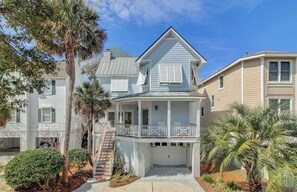 A two-story house with a front porch, a garage, and a staircase leading to the second floor.