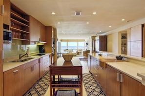 Una cocina moderna con armarios de madera, una isla central y vistas al exterior.