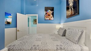 A bedroom with a bed, a door, and three wall-mounted pictures. - **ENDLESS SUMMER @ OLD TOWN** New Villa & Pool + Last Key White Glove Service... (Key West)