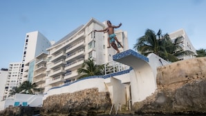 A man jumping off a building into the water. - Delightful Oceanfront 3BR Condo South tower,the best Ocean views in the complex! (Cozumel)