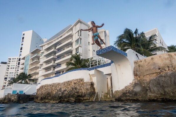 A man jumping off a building into the water.