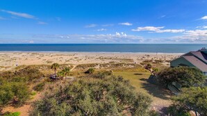 Blick auf einen Strand mit einem Haus und einem wolkenlosen Himmel.