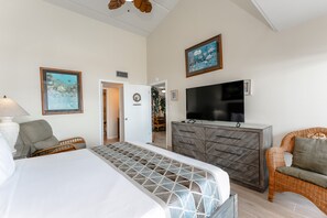 A hotel room with a bed, a TV, a dresser, and a chair.