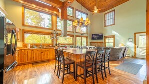 A spacious kitchen with a large island, wooden cabinets, and a modern refrigerator. - Beautiful Home, Views, Near Whiteface, Lake Placid (Wilmington)