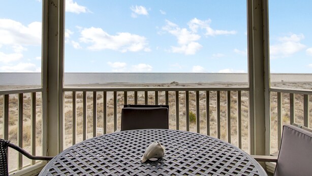 Un espacio de estar al aire libre techado con vista a la playa.