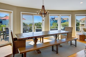 Enjoy meals and gatherings in this dining area with a large table and benches, offering views of the surrounding neighborhood.