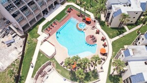 An aerial view of a hotel with a central swimming pool, multiple balconies, and outdoor seating areas.