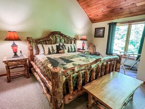 A rustic bedroom with a wooden bed frame, a wooden table, and two lamps.