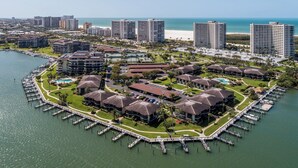 An aerial view of a coastal resort with multiple buildings, a marina, and a beach in the background. - South Seas T3-1509: Beautifully Updated Condo;  What a View! (Marco Island)