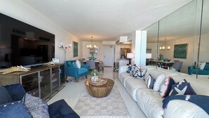 A modern living room with a sofa, coffee table, and a TV. - South Seas T3-1509: Beautifully Updated Condo;  What a View! (Marco Island)