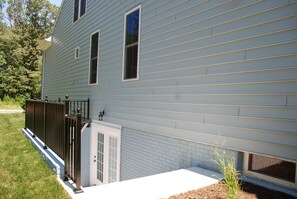 A light blue house with a black metal fence, a small window, and a door. - Spacious 5BR House, 2 pools & pickle ball, bike to beach, linen provided (Rehoboth Beach)