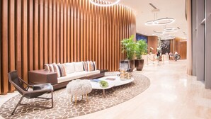 A modern lobby with a sofa, lounge chairs, a coffee table, and a giraffe-patterned rug. - 38th-floor beachfront residence with panoramic ocean & city views (Hollywood Beach)