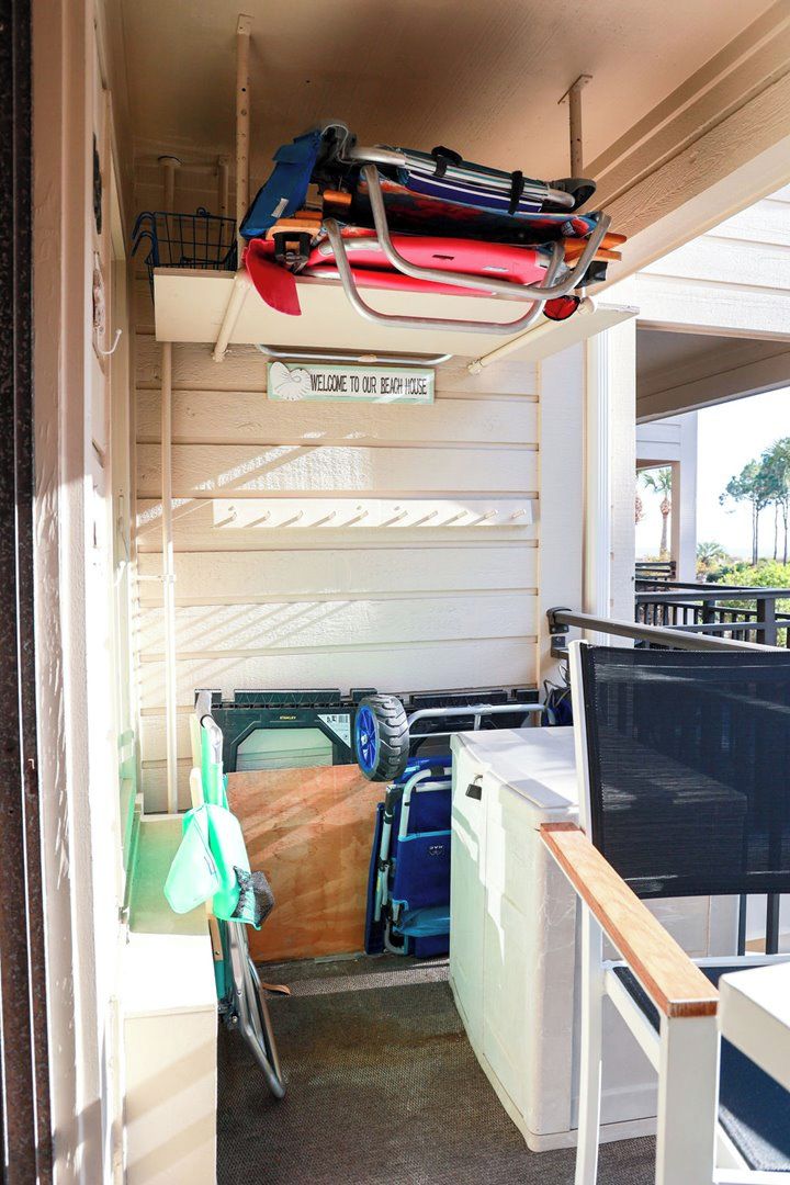 Une petite pièce comprenant un lit, un bureau et un téléviseur. Une pancarte indique : « Bienvenue dans notre maison de vacances en bord de mer. »