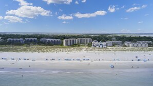 Ein Strand mit mehreren Hotels im Hintergrund.