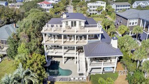 Une grande maison à plusieurs étages, dotée d’une piscine, de plusieurs terrasses et d’un vaste jardin.