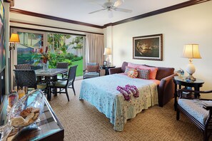 A hotel room with a bed, a dining area with a table and chairs, a ceiling fan, and a large window with curtains. - Waipouli Beach Resort Exquisite Grd Fr Pool View (Kapaa)