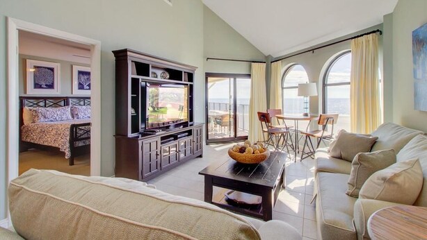 A spacious living room with a sofa, a TV, and a dining area with chairs.