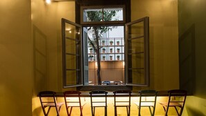 Ein Zimmer mit großem Fenster, einem kleinen Tisch und vier Stühlen.