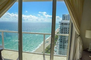 Ein Balkon mit Blick auf das Meer und einen Strand.