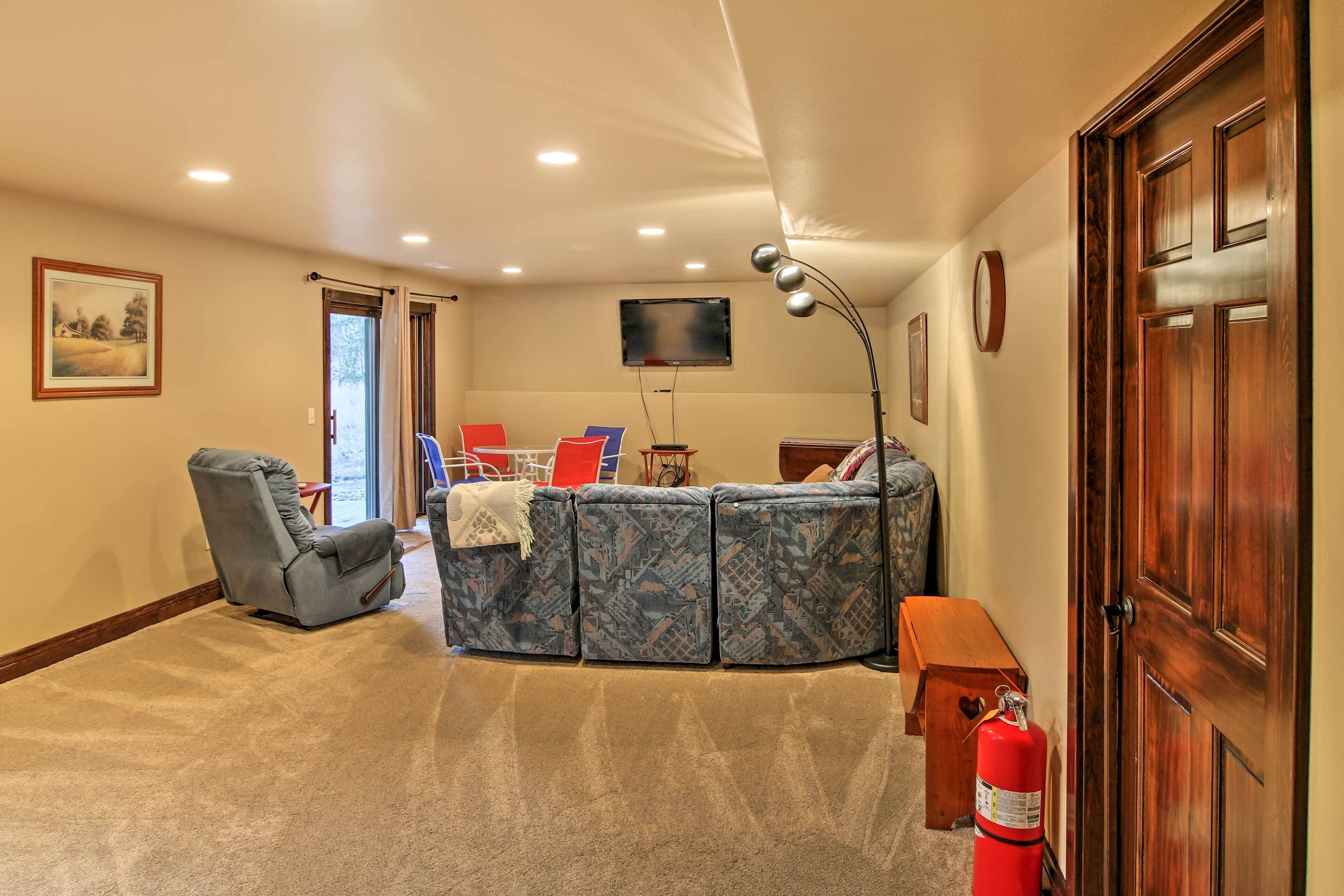 A living room with a sectional sofa, a recliner, a coffee table, and a television.