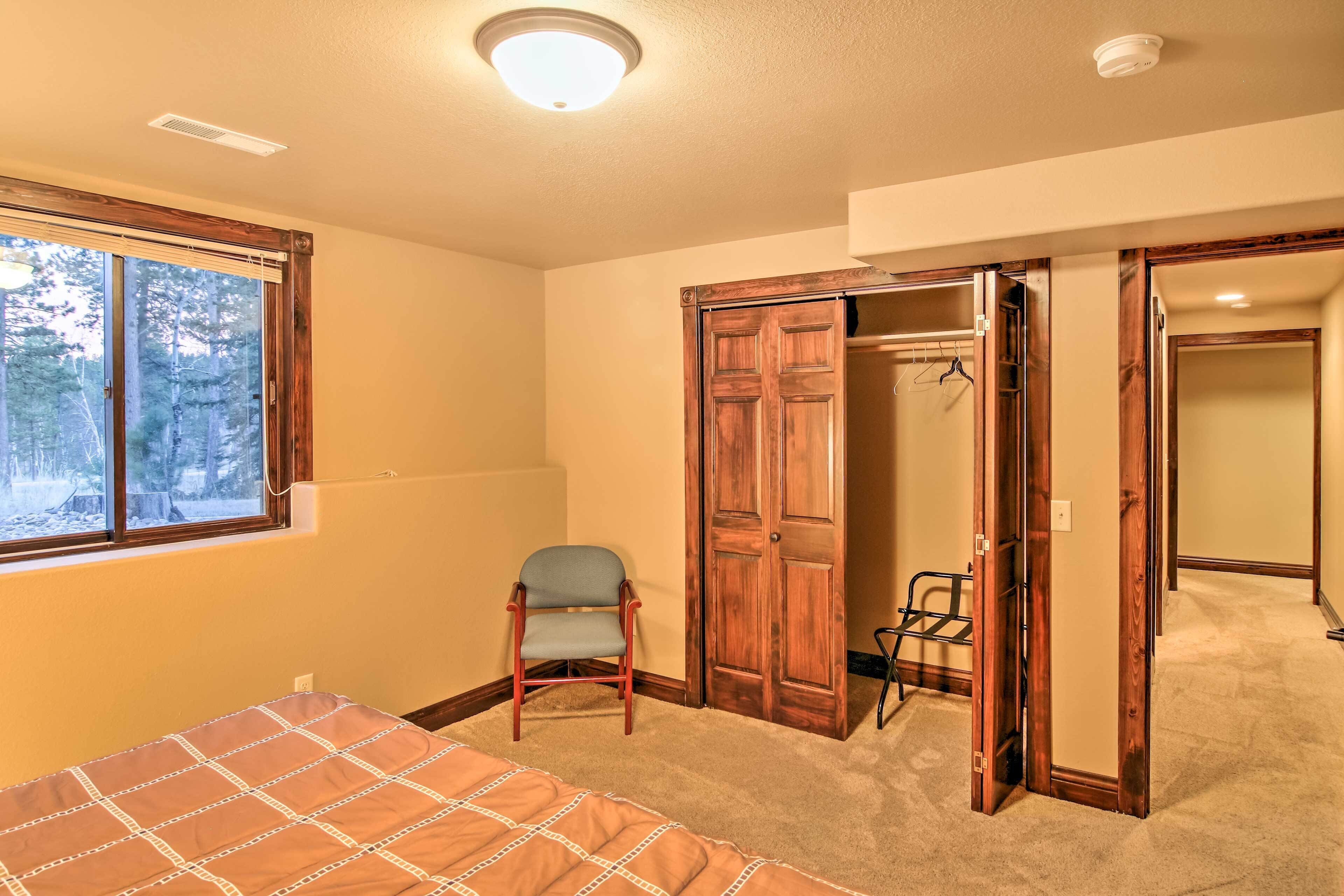 A bedroom with a bed, a chair, and a closet.