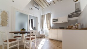 A kitchen with a dining table, chairs, a white cabinet, and a window with curtains. - Delightful apartment with mezzanine for 4 people, ideal for those who want to visit the city center (Firenze)