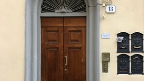 A double wooden door with a brass handle, a mailbox, and a house number 18 on the wall. - Delightful apartment with mezzanine for 4 people, ideal for those who want to visit the city center (Firenze)