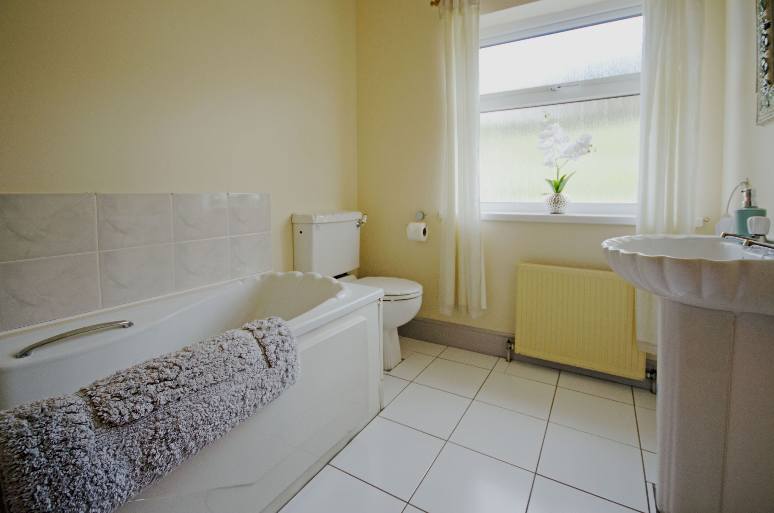 A bathroom with a bathtub, toilet, and sink.