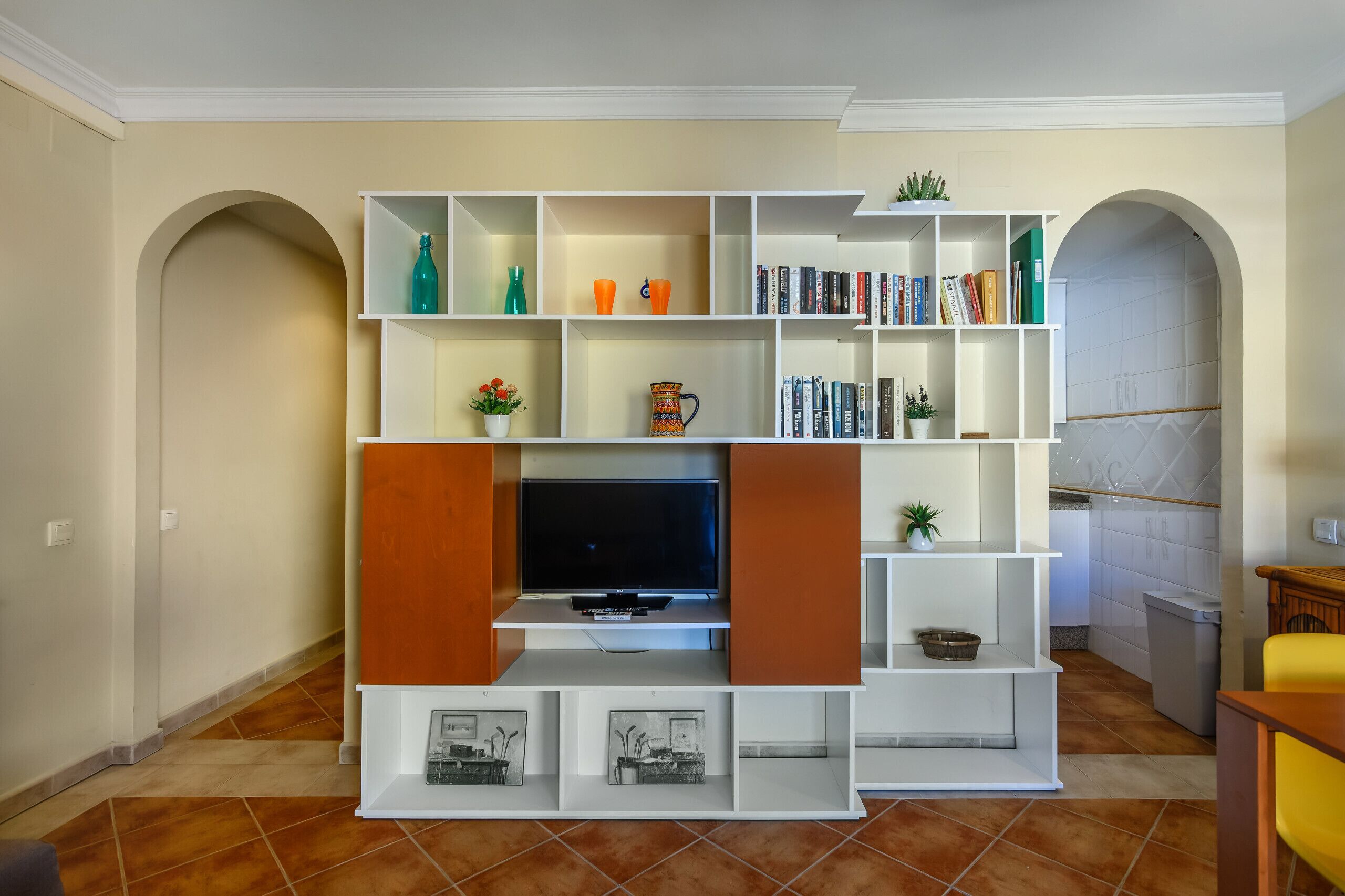 A living room with a built-in entertainment unit, bookshelves, and a television.