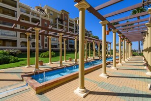 Ein Hotelinnenhof mit einem zentralen Wasserspiel, Säulen und einem überdachten Gang.