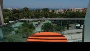 Un balcón con vistas a una zona residencial y al mar.