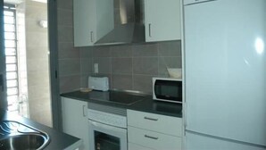 Cozinha com armários brancos, micro-ondas e torradeira.