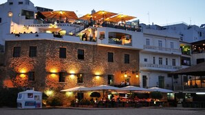 Un restaurant doté d’une terrasse et d’une façade en pierre.