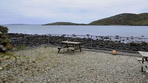 A rocky beach area with a picnic table and a soccer ball. - Cottage 108 - Cleggan (Cleggan)