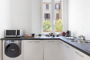 A compact kitchen with a washing machine, a microwave, and a sink. - UR-NEST Battisti 2 Deluxe (Bologna)