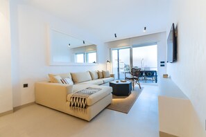 Un salon moderne avec un canapé, une table basse et un coin repas.